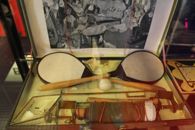 Hierbei handelt es sich um ein französisches Pim Pam-Set aus dem Jahr 1901, also ein ganz frühes Exemplar unseres Sportgeräts. Das Bild im Deckel des Kartons zeigt eine feine Gesellschaft, die 'Pim Pam' spielt (©Schäbitz)