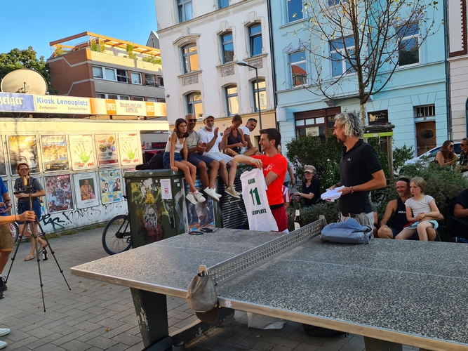 Zur Erinnerung an den Lenauplatz 11, wo die Steinplatte steht, bekommt der 41-jährige Amerikaner ein T-Shirt geschenkt. ... (©Thätner)
