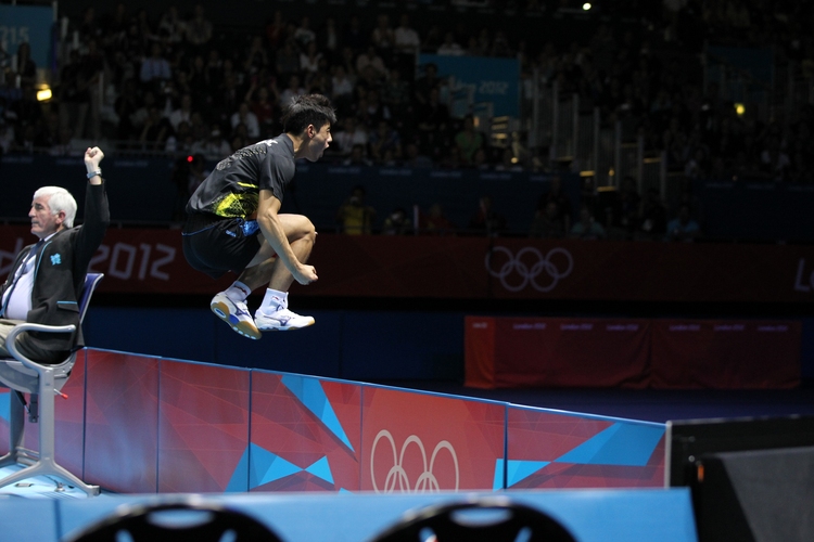 Jubel: Zhang Jike.
Nun haben wir schon ein großartiges Technik-, Fitness- und Taktikpaket zusammen. Doch dies nützt alles nichts, wenn unser 'TT-Monster' teilnahmslos zurück in die Box wandert, wenn er gerade Olympiasieger geworden ist. Zhang Jike fällt nicht nur durch seine spielerische Stärke auf, sondern auch durch die Art und Weise, wie er seine großen Siege feiert. Da mussten schon Trikots und Umrandungen dran glauben. (©ITTF)