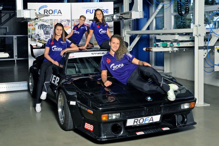 Auf einem BMW des Sponsors ROFA zeigen sich die Spielerinnen des SV DJK Kolbermoor im dunkelblauen Trikot... (©SV DJK Kolbermoor)