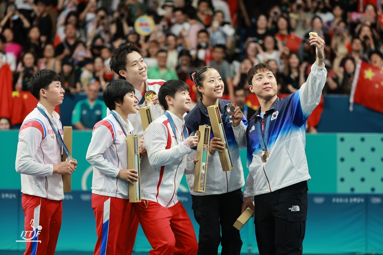 Ein Bild mit Seltenheitswert: Nord- und südkoreanische Sportler posieren gemeinsam für ein Sieger-Selfie (©ITTF)