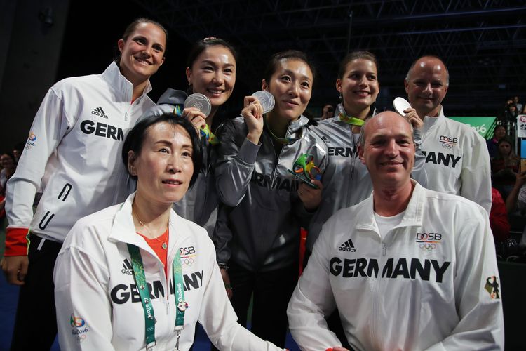 ...aber auch bei den deutschen Spielerinnen, Bundestrainerin Jie Schöpp, Mannschaftsarzt Toni Kass (2. v. r.) und Sportdirektor Richard Prause (Flickr/ITTFWorld)