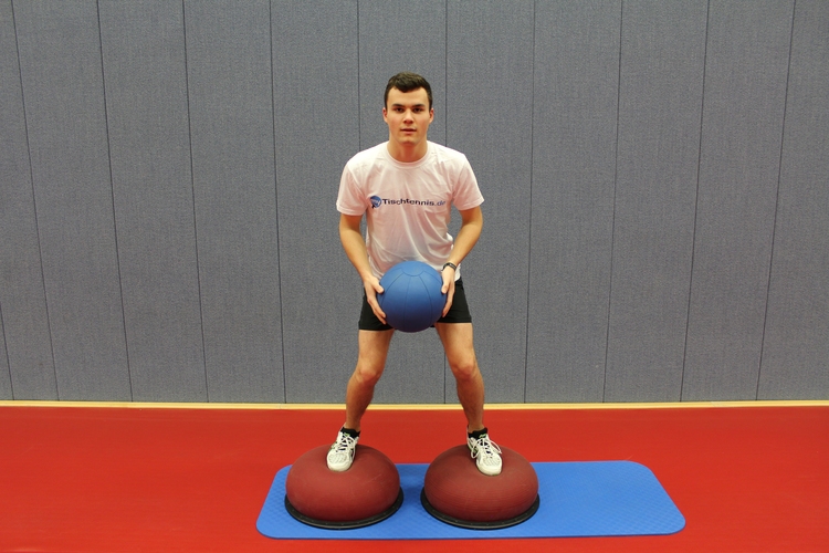 Übung 5 (Medizinballwurf gegen Wand "rückwärts"): Wer den Schwierigkeitsgrad erhöhen möchte, stellt sich auf einen Togu-Ball oder eine Airex-Matte. (©Schäbitz) 