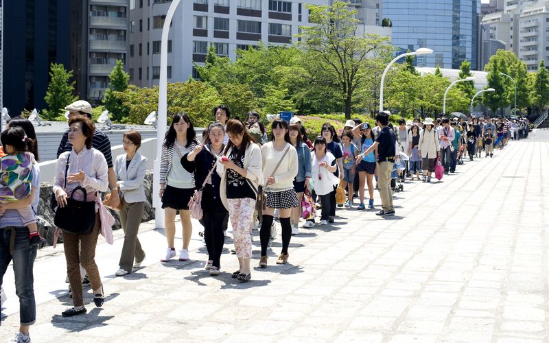 Vor dem Yoyogi Gymnasium in Tokio bildete sich eine lange Schlange, die Spätentschlossenen versuchten noch eine Karte zu ergattern. (©Stosik)